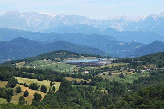 Fotografija SE Kanalski Vrh ( črpalna hidroelektrarna ČHE Avče). V ozadju je vidna hribovita narava obdana z gozdovi.